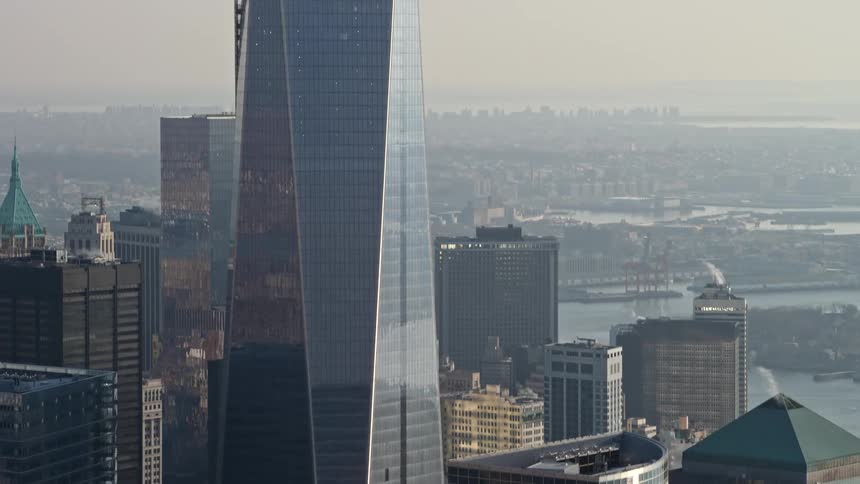 Aerial footage of Freedom Tower in Lower Manhattan New York during winter as the camera tilts up from the base of the skyscraper
