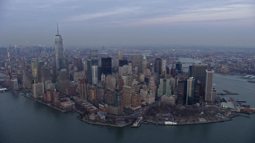 Aerial footage of Battery Park and Lower Manhattan skyscrapers during twilight winter in New York City