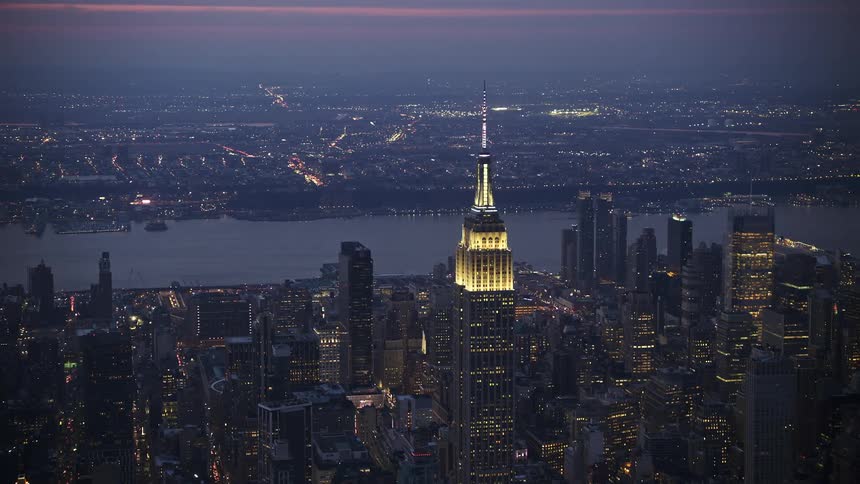 Approaching and flying by the iconic Empire State Building in Midtown Manhattan during the hazy winter twilight