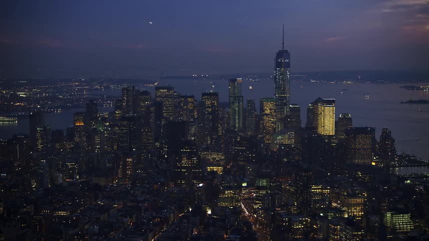 A breathtaking aerial view of the illuminated Freedom Tower and Lower Manhattan at twilight seen from Midtown Manhattan in the winter