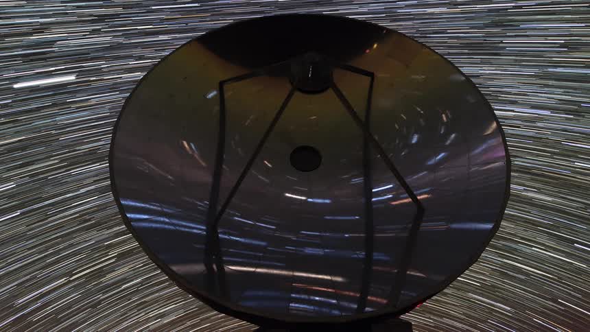 A satellite dish looks like its in space with stars spinning around it