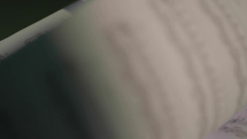 A person flips through a book of sheet music