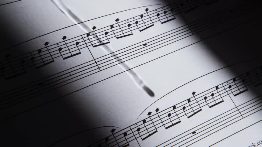 The shadow of a drop of water is seen atop a page of sheet music