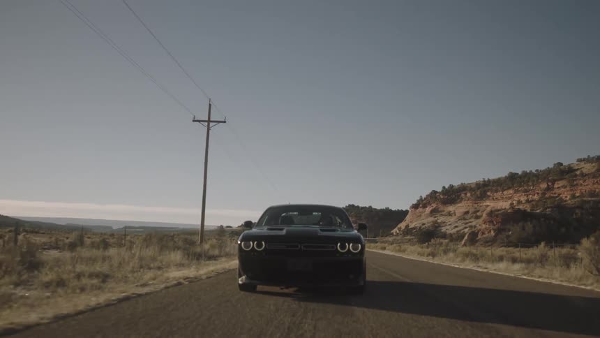 A car races down the road on a sunny day