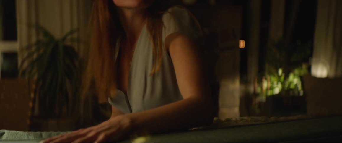 A woman is seen sitting on a couch