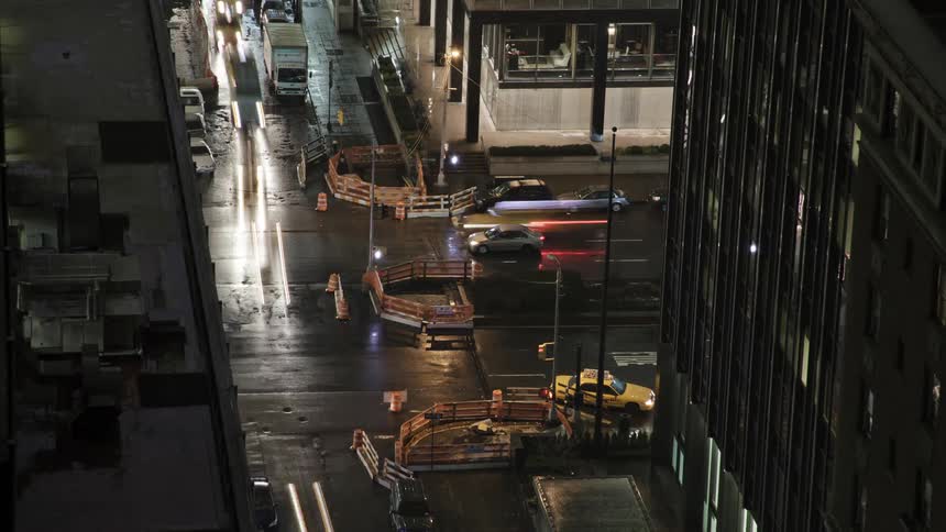 Traffic travels through an intersection in a metropolis at night