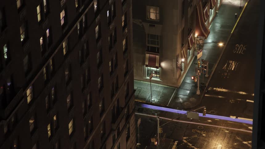 Down below a street is shown at night with cars moving busily