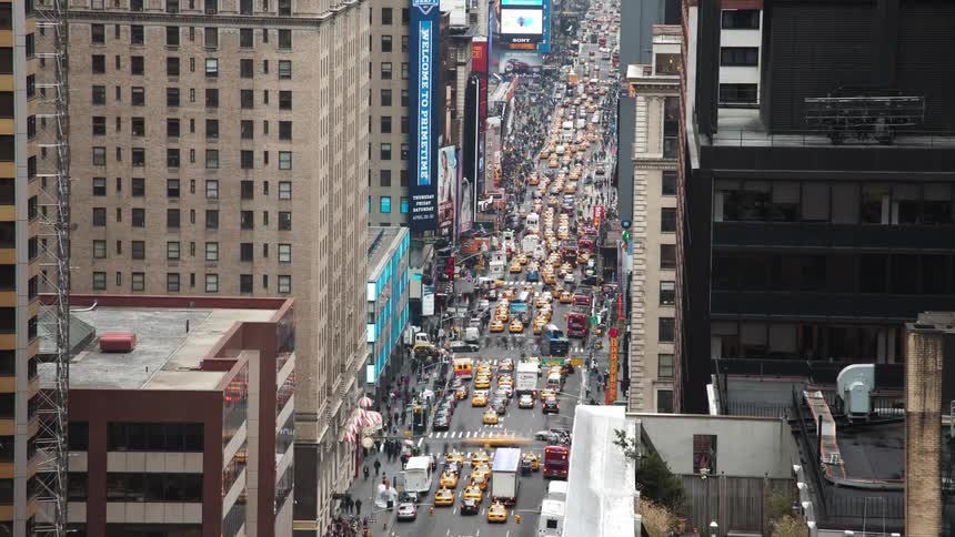 Aerial view of traffic jam and people walking down the busy street in downtown area