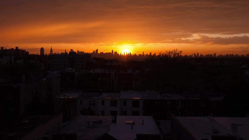The sun goes down behind skyline of new york city