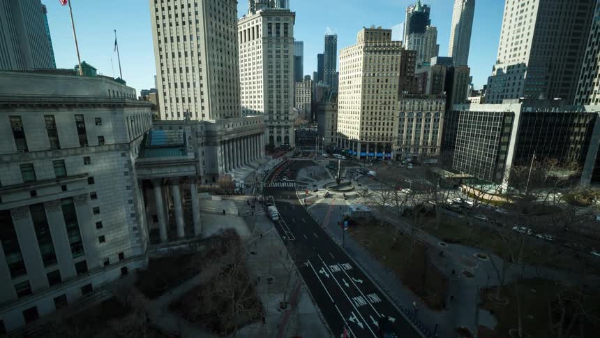 Traffic moves along downtown streets past small park