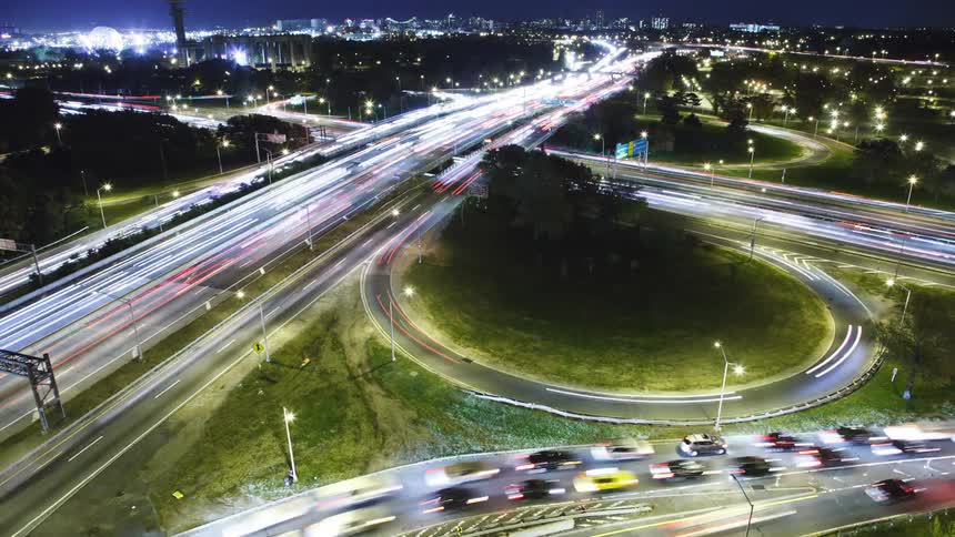 Heavy traffic travels through an interchange in a metropolis at night