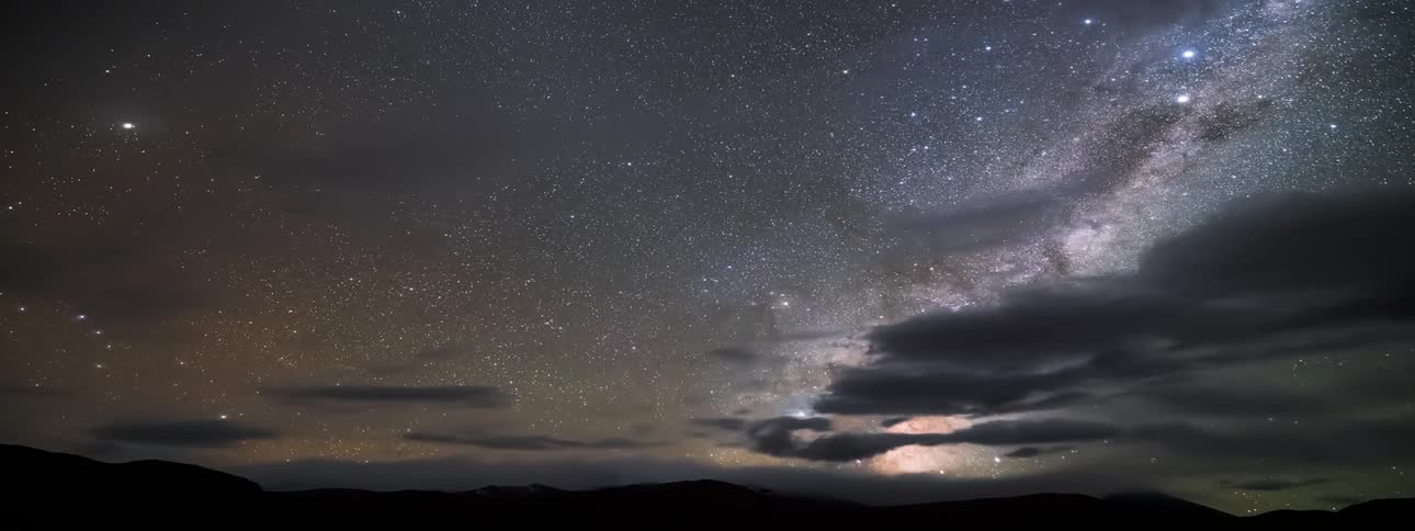 Time lapse of the milky way rising over the mountains on a starry night sky