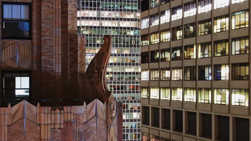 Time lapse of the lights of buildings in the city skyline going out from night to day