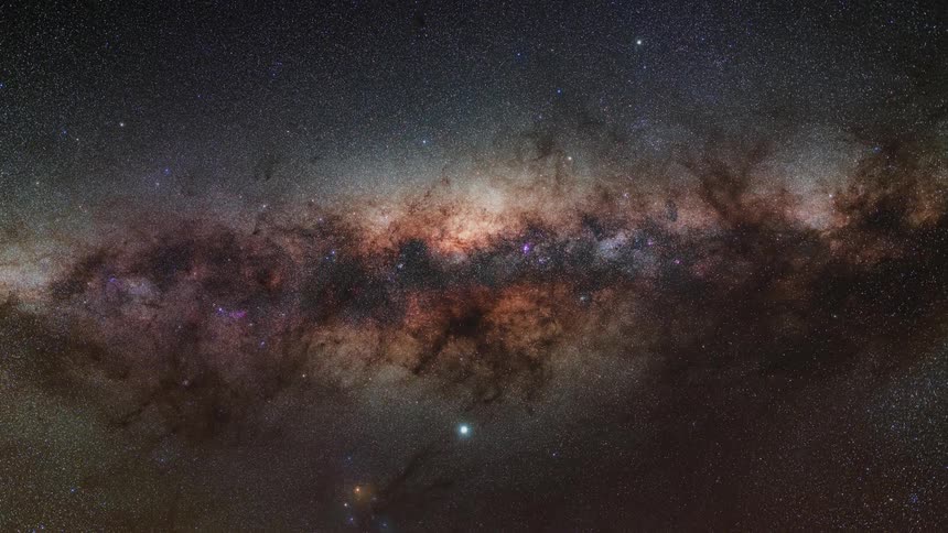 Stars twinkle as a dark nebula glows in space and clouds turn orange as the sun rises over the mountain