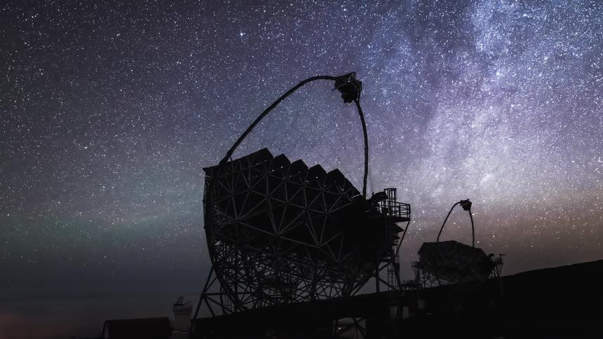 Timelapse of the silhouette of a couple telescopes following the stars on a starry night