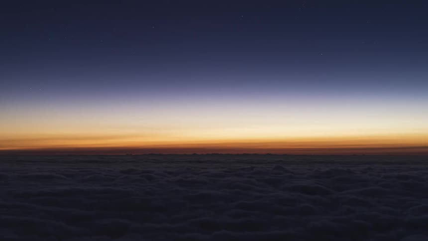 A time lapse shows a layer of clouds passing by a beautifully illuminated sky