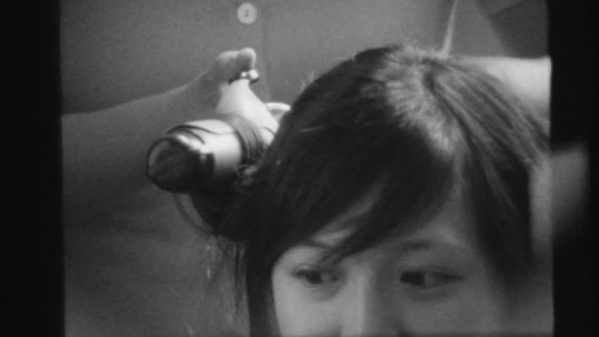 A woman is curling a persons hair on film