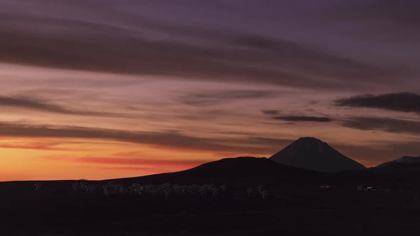 Clouds floating over a silhouetted mountain landscape at sunset