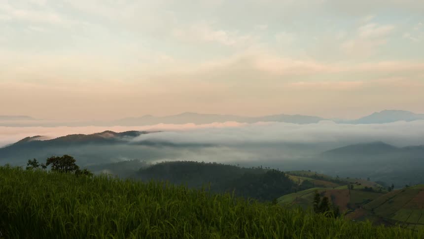 Clouds and fog sweep over the rolling countryside during the day