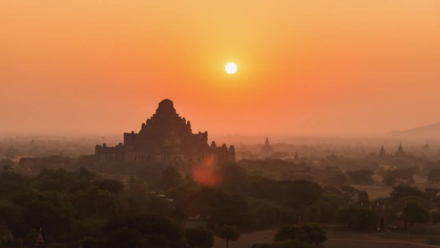 A timelapse of a sunrise over a city in a valley or mountainous area
