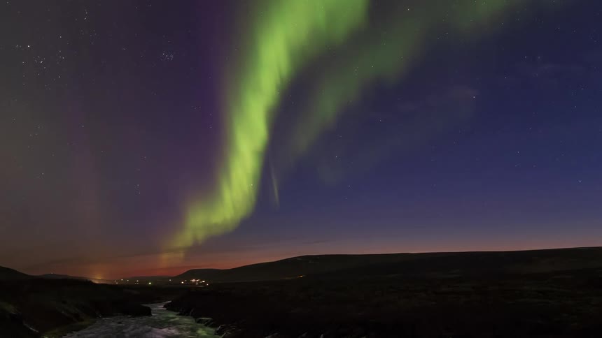 The northern lights waver brilliantly overhead in the nighttime sky