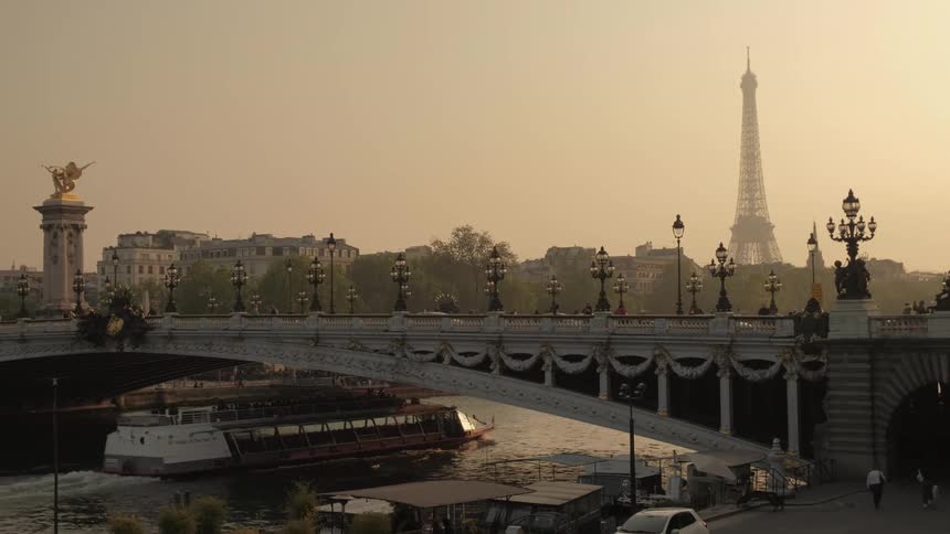 Traffic travels across a bridge as a ferry passes beneath it on the river below