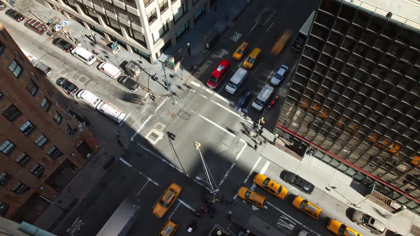 Aerial view of intersection with vehicles and pedestrians in the busy city street
