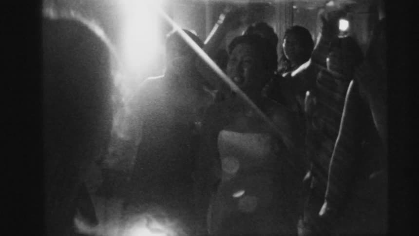Group of friends dancing after a wedding caught on vintage black and white film