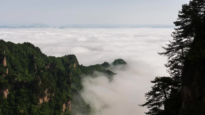 Time lapse of a layer of clouds covering the peaks of a mountain range at daytime