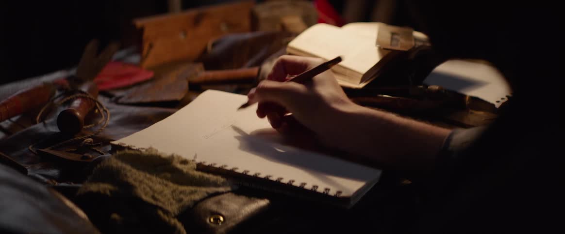 Pencil is used to write and underline text in a spiral notebook