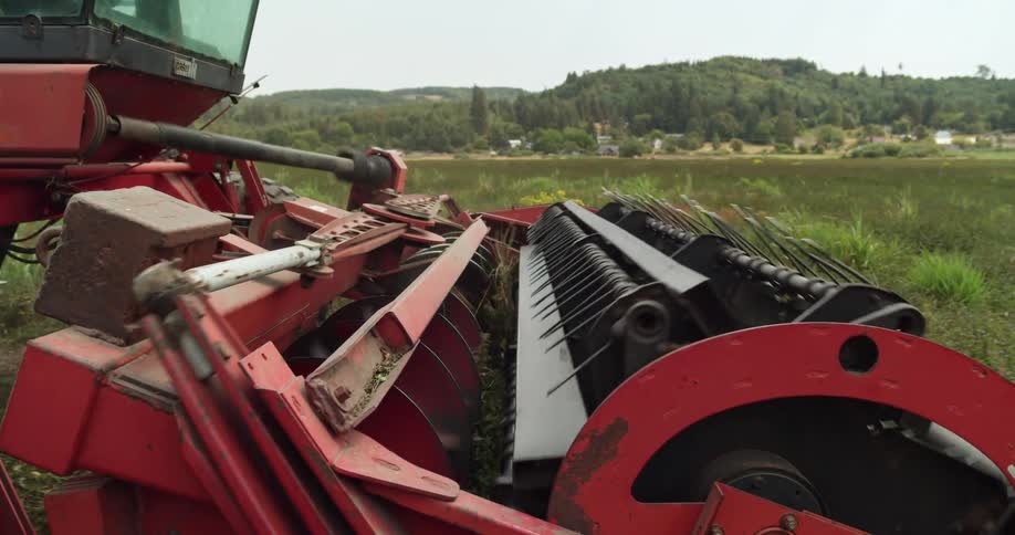 The spreader turns on a tractor as it plows a field on a farm