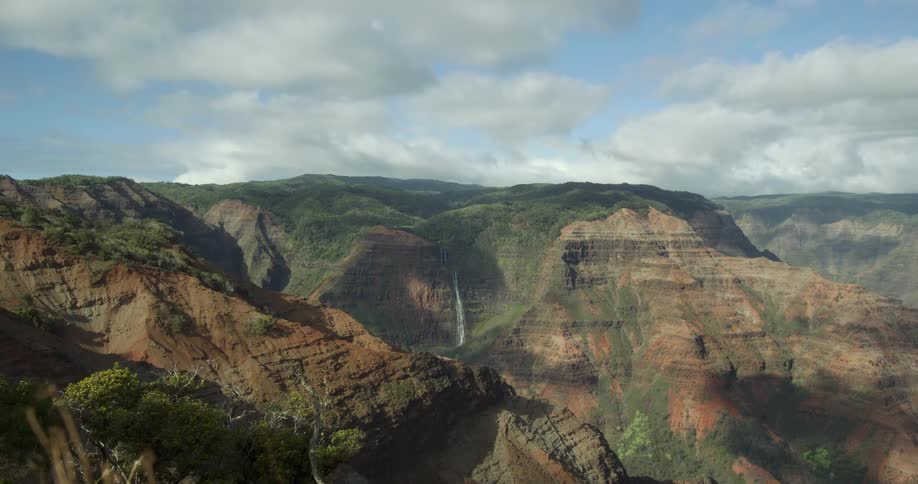 Aerial view of a waterfall nested between the mountains at daytime