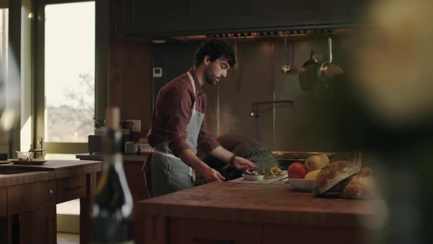 A couple of chefs prepare food on the kitchen of a luxurious house
