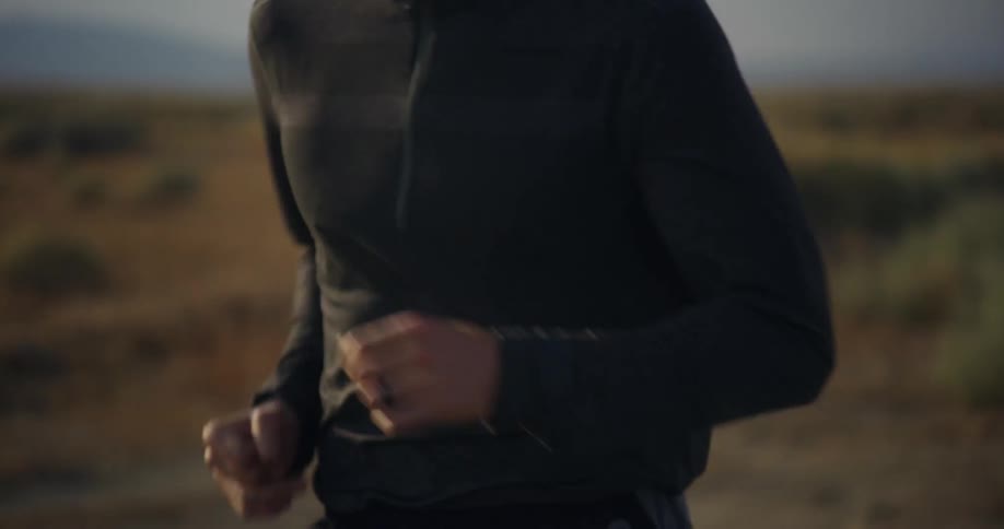 Close up view of a man jogging outdoors during the daytime