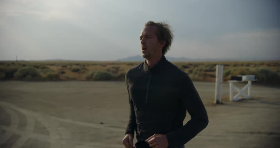 Man jogs along country road past mailboxes with mountain on the horizon