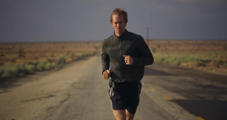 A man is running on an open rural road