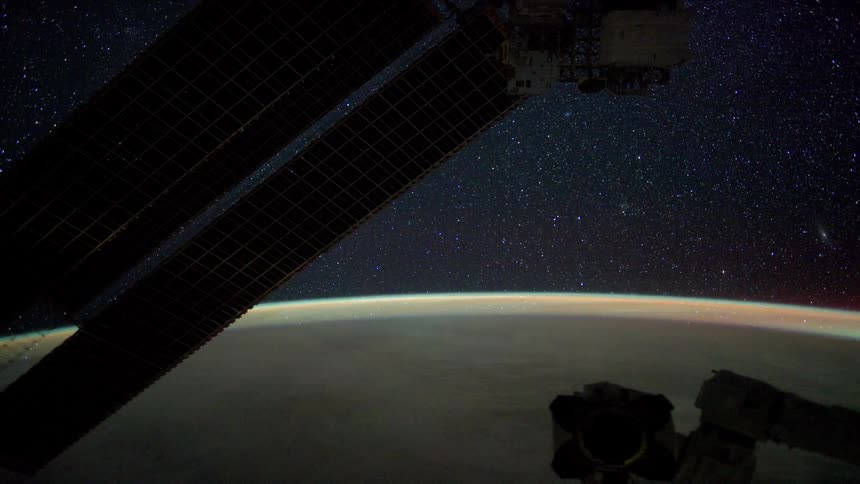 A satellite flies in space as lights flash on the earths surface