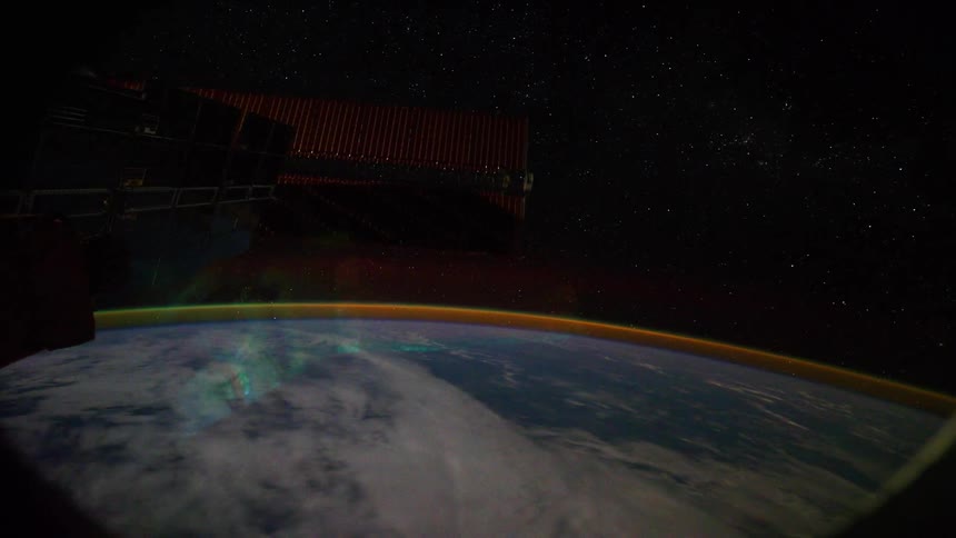 Solar panels on space station rotate as sun glares onto portal and aurora borealis shines in atmosphere