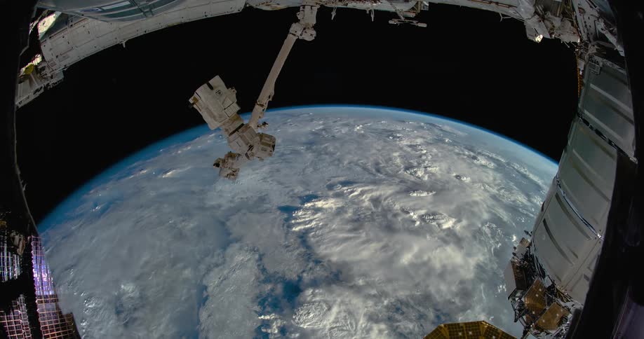 A satellite flies in space as the earth rotates in the darkness