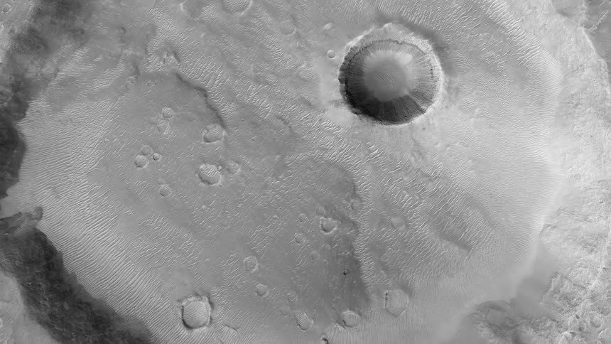 Craters of various sizes sit inside a larger crater on the moon