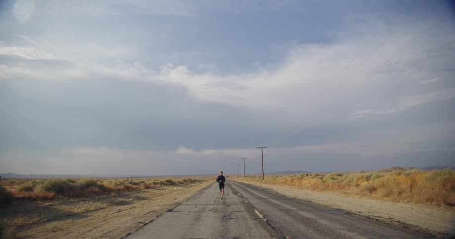Slow motion of a man jogging outdoors in a rural area