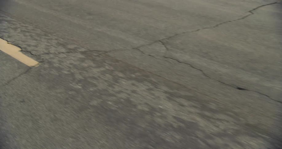Close up of the cracks and seams on the asphalt of a rural road in bad condition at daytime