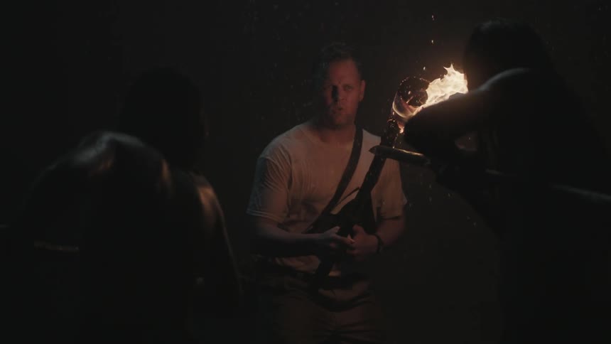 A man waves a torch in a cave