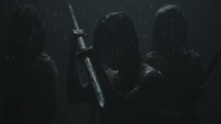 A group of women holding weapons in the rain