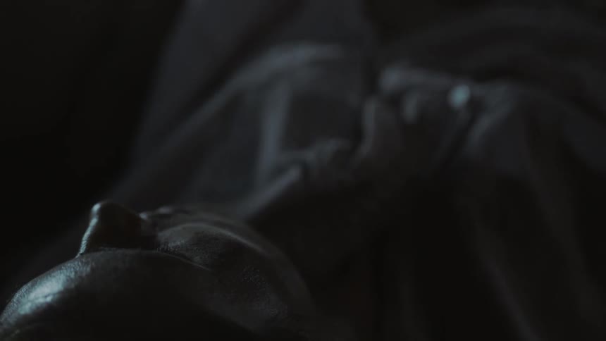 A person is laying down in a dark area