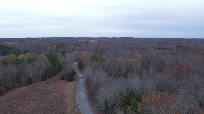 A car travels down a road into the distance