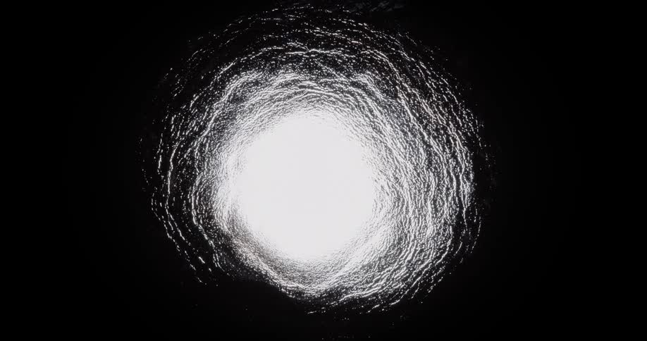 White mizture spreads through then shrinks in dark background