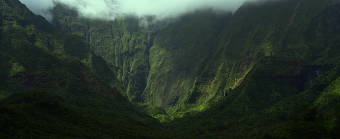 Aerial view of mountains covered in fog is displayed