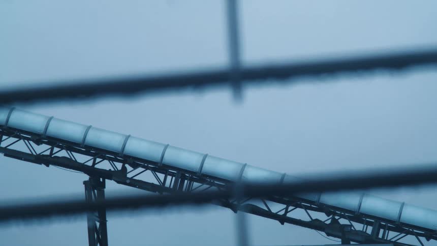 A tube is on the frame of a machine as snow falls