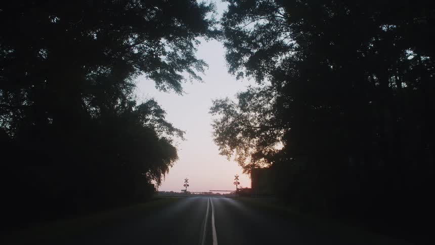 A railroad crossing and a train near a road